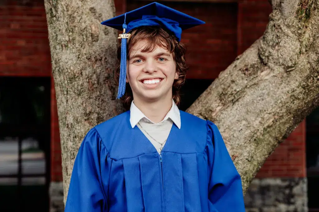 A Person Is Celebrating Their Graduation In A Cap And Gown.