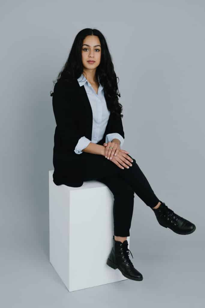 A person sits on a white box.