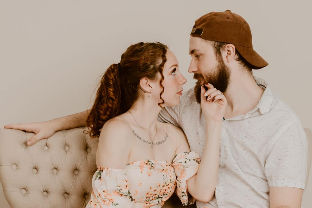 Two people sit on a couch.