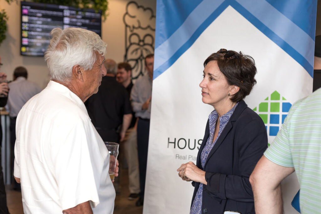 Two people converse at an event near a