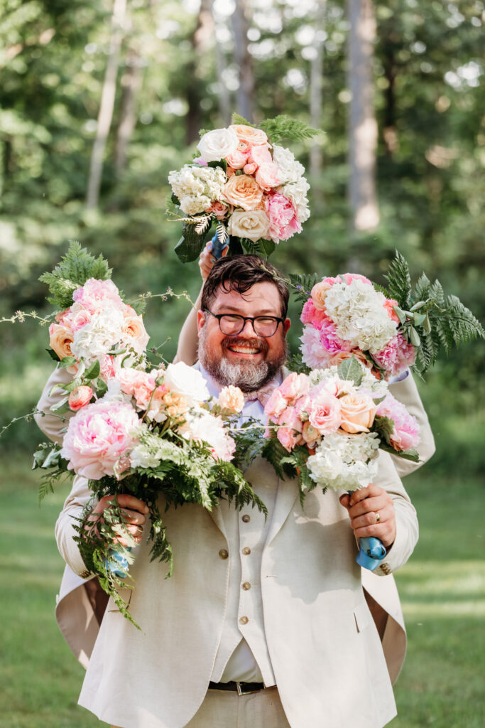 Groom happily holding bouquets